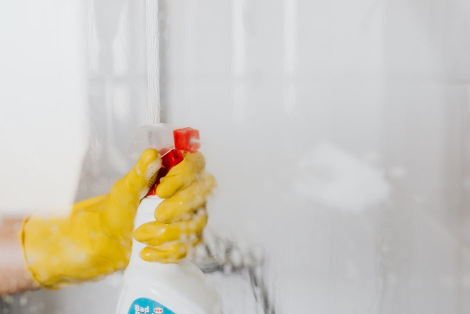 Een hand die een effectieve vlekkenreiniger gebruikt op een tapijt in een woonkamer.
